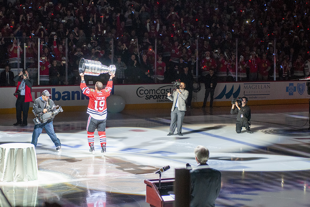 Jonathan Toews holds high Stanley Cup for banner raising ceremony