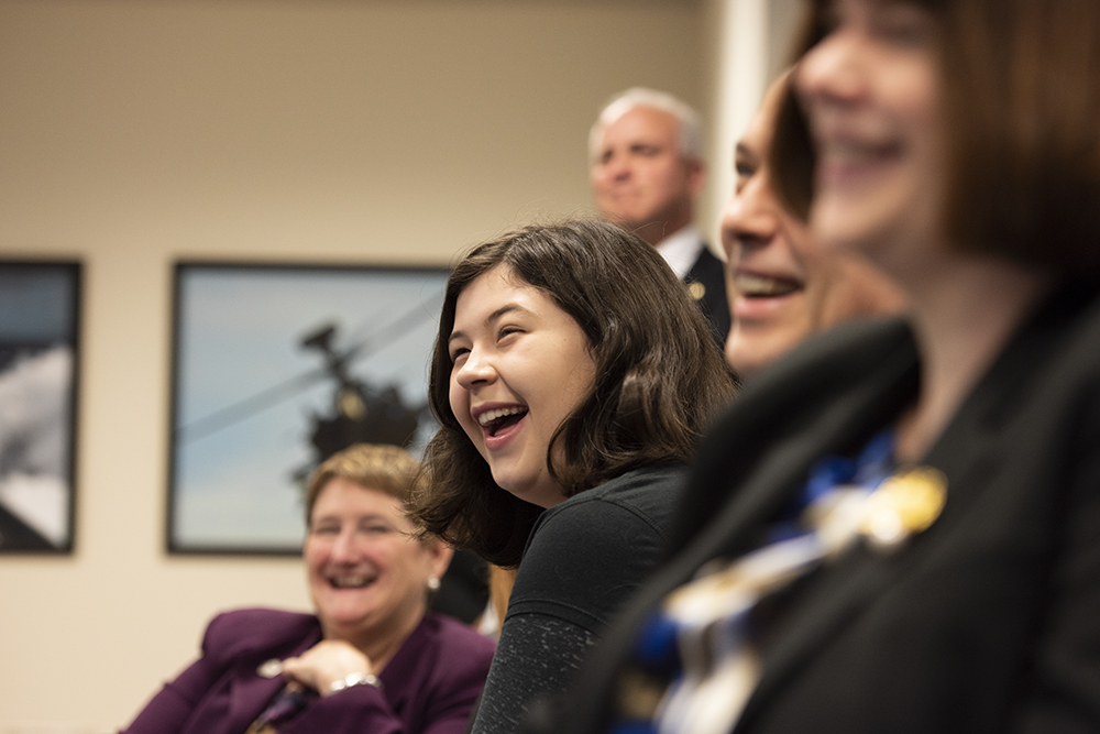 A daughter of an SES laughs at a joke during a swearing-in ceremony