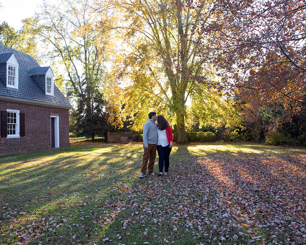 Newly engaged couple posing for a picture under a tree