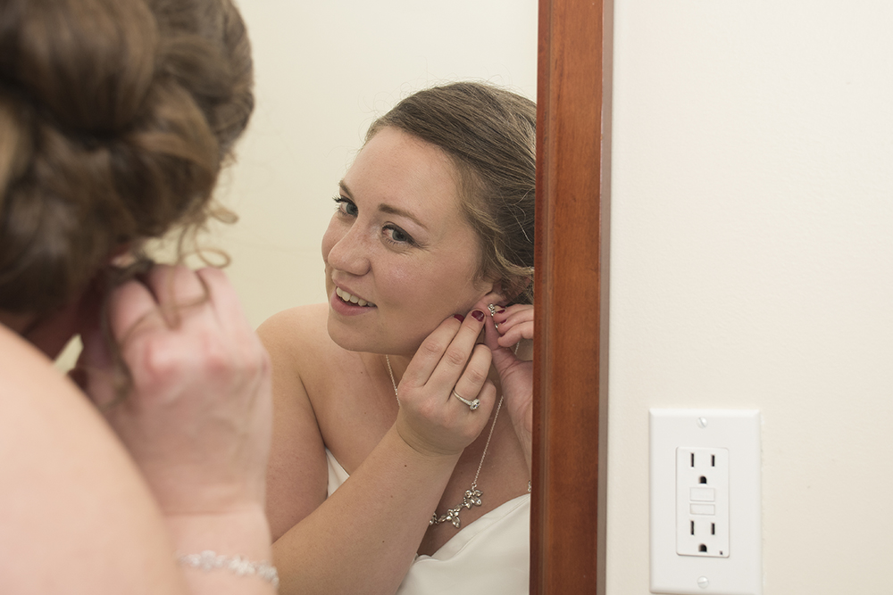 Bride getting ready for her wedding by putting earrings on