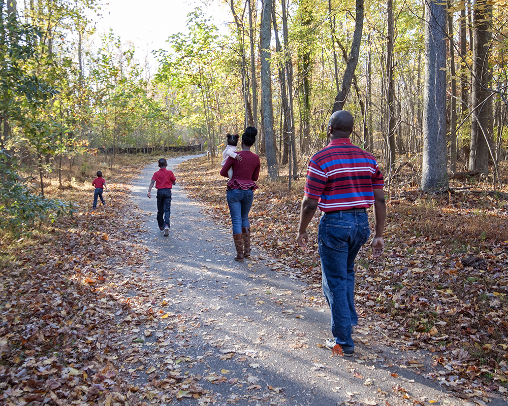 Family walking along path posing for a picture