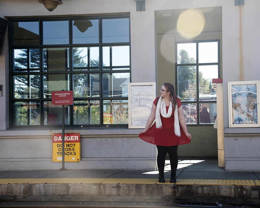 Young female posing for senior picture on location at train