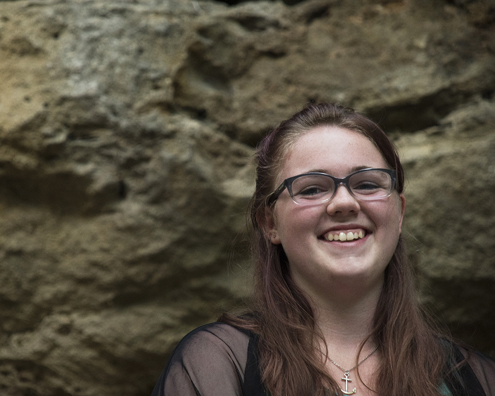 Young female posing for senior picture on location smiling
