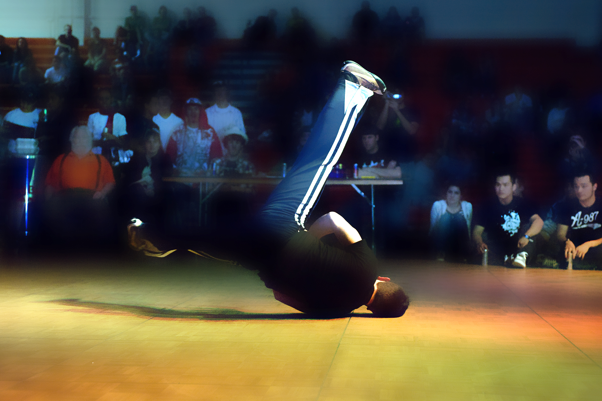 Young male doing a breakdance windmill move in a college competition